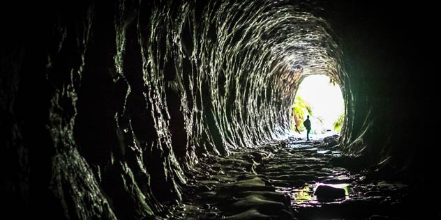 A silhouette of a person in the distance in the end of an old railway tunnel
