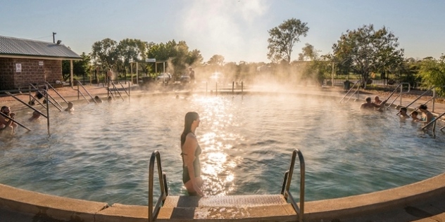 woman stepping into a steaming round pool