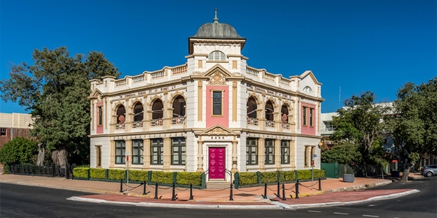 edwardian-style former bank converted to an art gallery sits on the corner of the street and has many windows and a cerise-coloured door